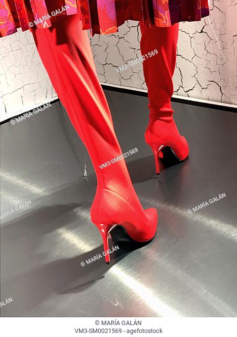 Mannequin's feet wearing red high-heeled boots in a shop window. Serrano street, Madrid, Spain