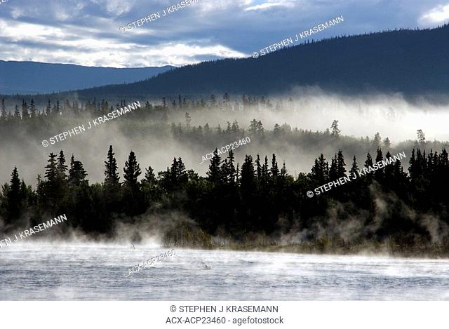 Fog over Yukon River with Gray Mountain in the background. Yukon Territory, Canada