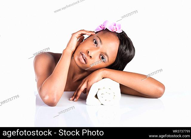 Young African woman in Studio doing body care with towel taking bath for young and beautiful skin and relaxation