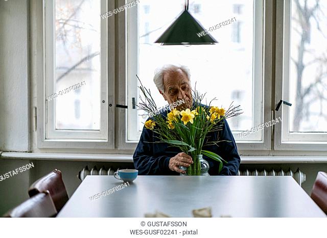 Senior man with bunch of flowers at home