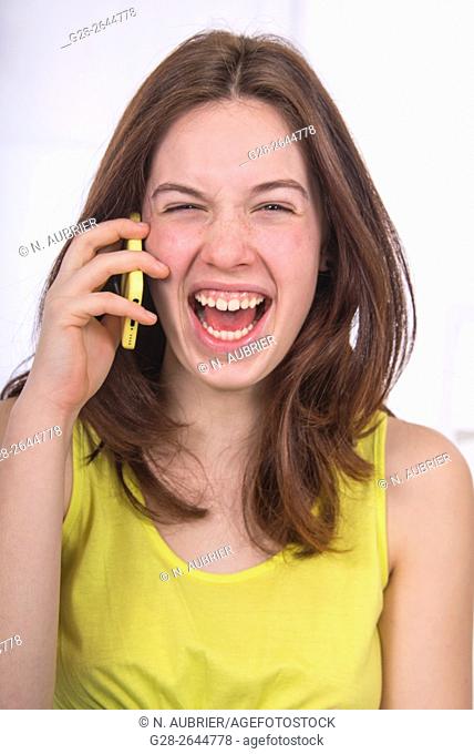 Teenage girl using a cellphone, and laughing