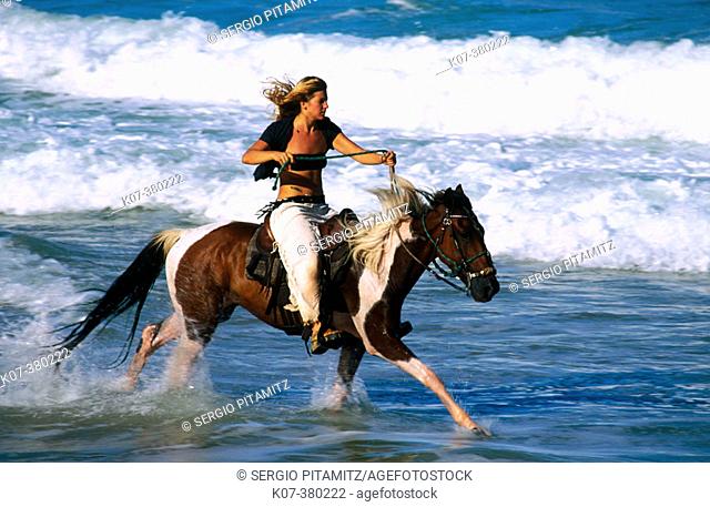 Woman riding horse in the beach, Tibau do Sul. Rio Grande do Norte state, Brazil