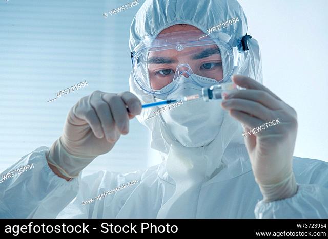 Wear protective clothing a doctor with a syringe