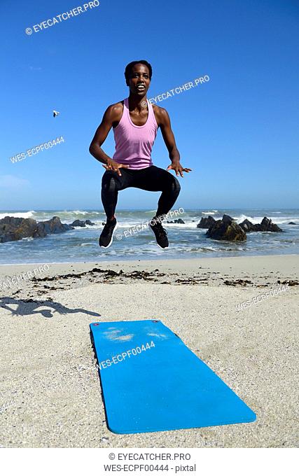 Sportive woman jumping on the beach
