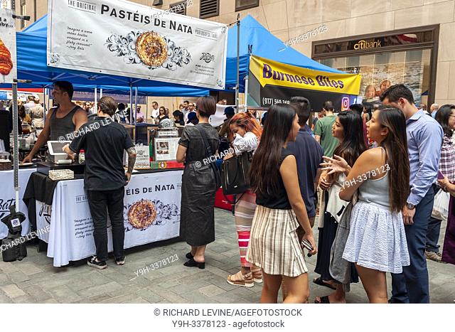 Tourists and office workers line up at Pasteis De Nata in The Outpost of the Queens Night Market, located in Rockefeller Plaza in New York on Tuesday, July 30