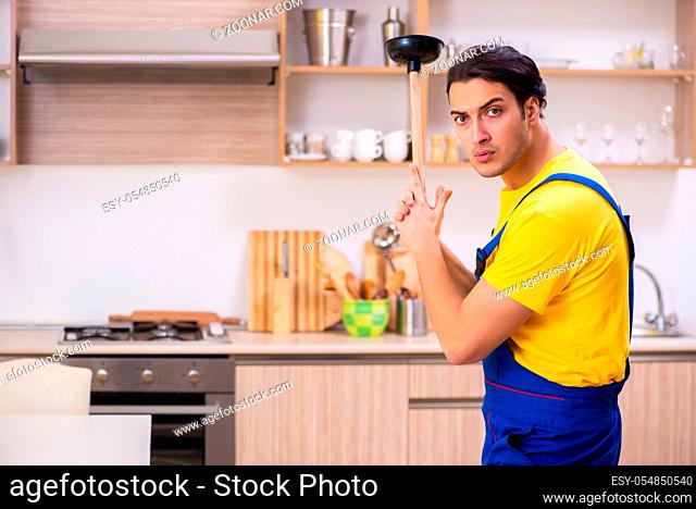 The young male contractor repairing tap at home
