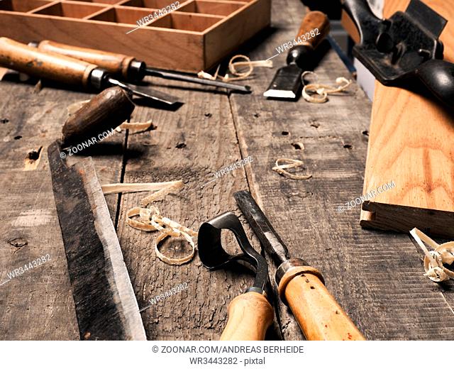 Carpenter tools on a rustic wooden background with space for text