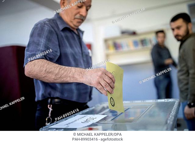 A man comes out of a polling booth with his ballot at a polling station in Istambul, Turkey, 16 April 2017. Turkish citizens are voting on a constitutional...
