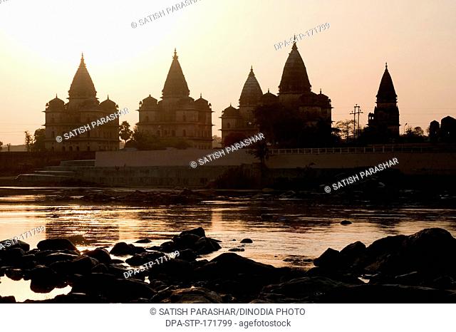 Sunset with cenotaphs at bank of river Betwa , Orchha , Tikamgarh , Madhya Pradesh , India