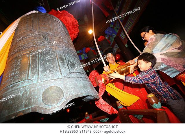 (180216) -- SANYA, Feb. 16, 2018 () -- Monk and tourists strike a bell in Sanya, south China's Hainan Province, Feb. 15, 2018