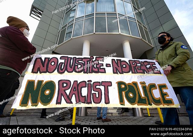 18 February 2021, Baden-Wuerttemberg, Stuttgart: Demonstrators hold a banner with the inscription ""No justice - no peace no racist police"" at the start of a...
