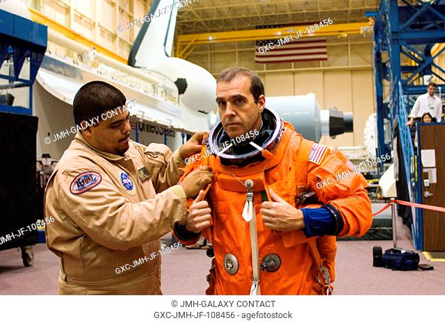 Astronaut Richard A. (Rick) Mastracchio (right), STS-118 mission specialist, dons a training version of his shuttle launch and entry suit prior to the start of...