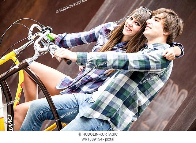 Young couple on bicycles, embracing, Osijek, Croatia