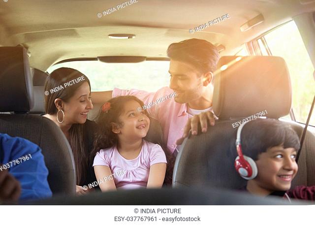Happy young family travelling in car