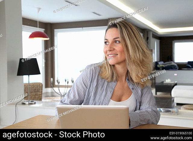 Smiling woman connected on internet at home