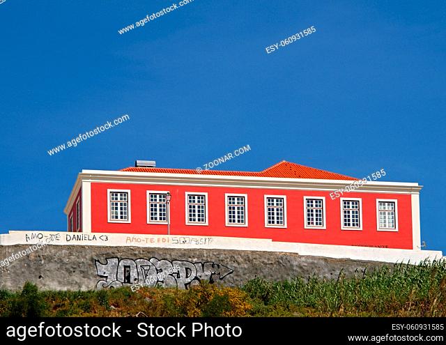 Rotes Haus auf den Huegeln von Sines mit blauem Himmel