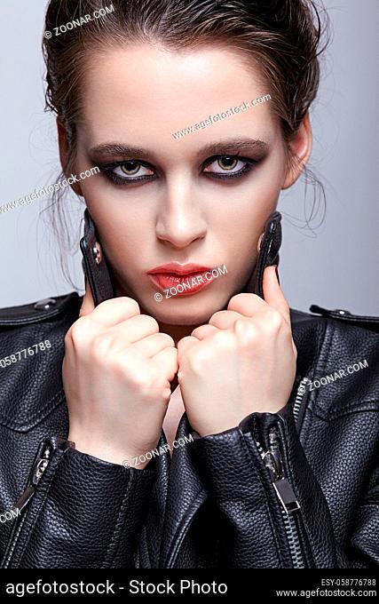 Portrait of female in black leather jacket. Woman with unusual beauty evening makeup. Girl with perfect skin, green pistachio colour eyes and violet - black...