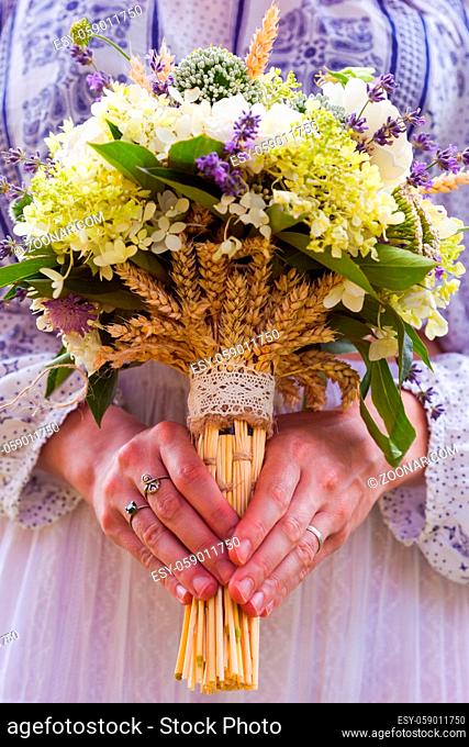 Stylish eclectic wedding bouquet in the bride's hands close up