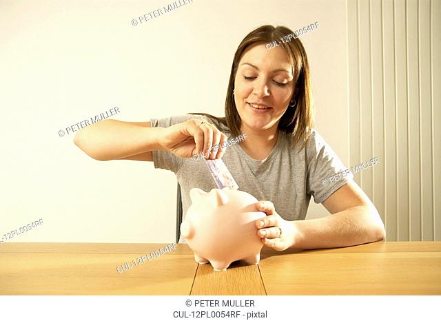 woman saving in piggy bank