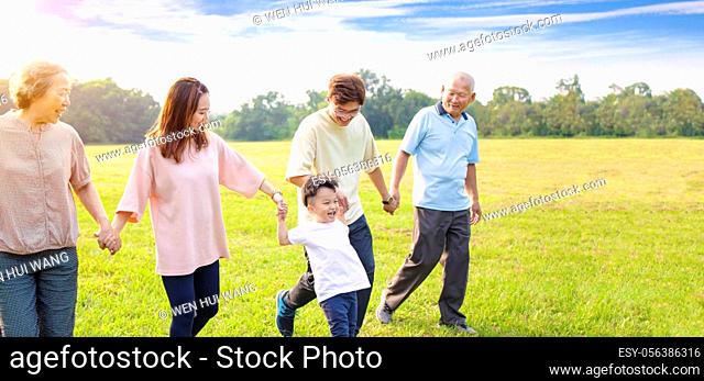 three generation asian family walking in the park
