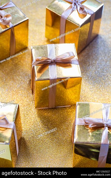 Group of gold sparkling gift boxes, beautiful gold packaging surprise with bow on sparkling background party concept