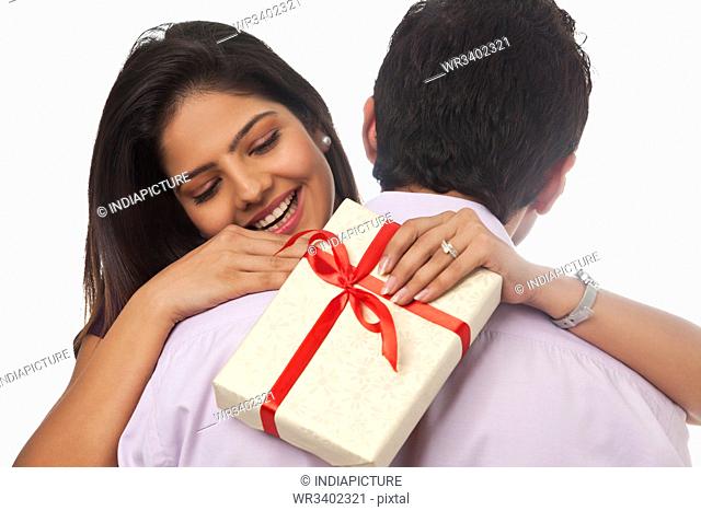 Rear view of a woman holding a gift smiling