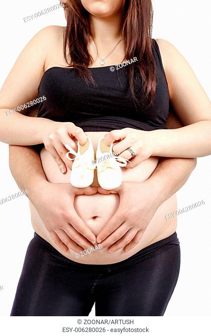 pregnant woman with a child's shoe