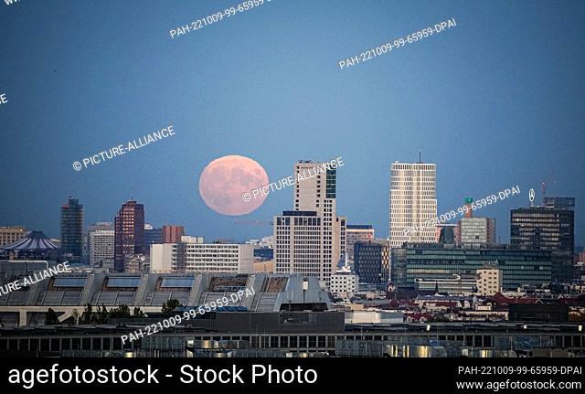 09 October 2022, Berlin: The full moon rises behind City-West shortly after sunset. Photo: Kay Nietfeld/dpa. - Berlin/Berlin/Germany
