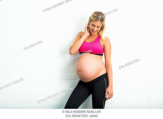 Full term pregnancy young woman wearing sports clothing
