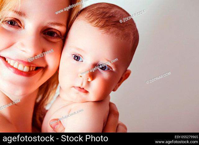 Happy mother with her baby on white. Matherhood and maternity concept