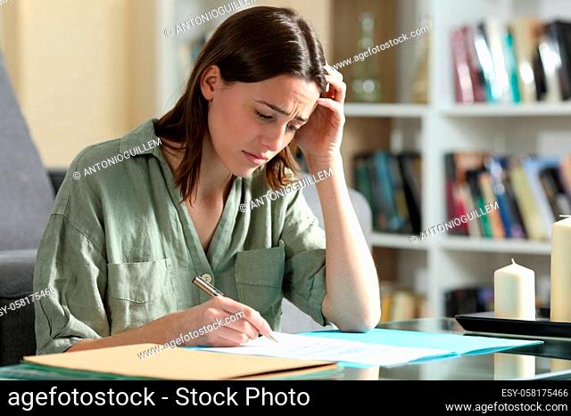 Sad woman ready to sign a contract at home