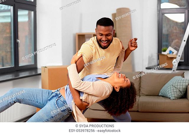 happy couple moving to new home and dancing