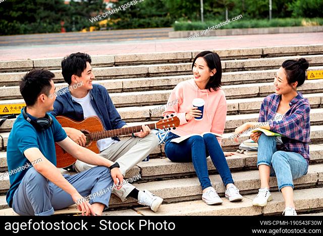 The young college students sat down on the steps, nd chatting