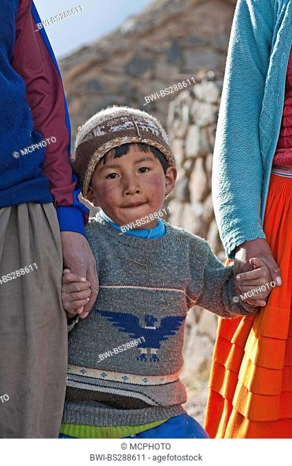 Quechua boy at his parents' hands, Peru, Atuncolla