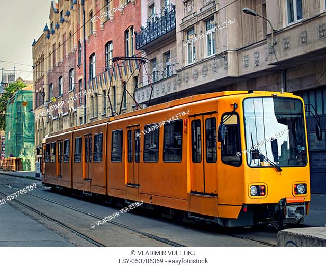 Orange electric tram in Budapest at the starting tram station, waiting for passengers