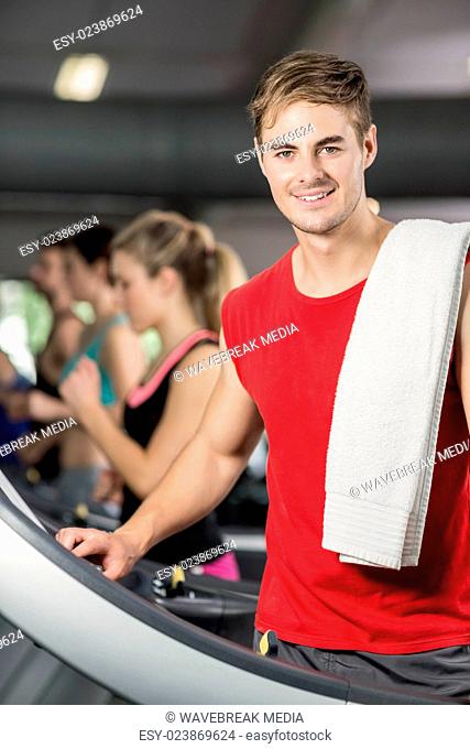 Smiling muscular man on treadmill