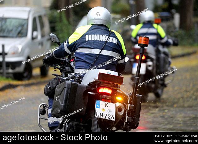 21 October 2020, North Rhine-Westphalia, Cologne: Employees of the public order office drive through the streets at the university hospital