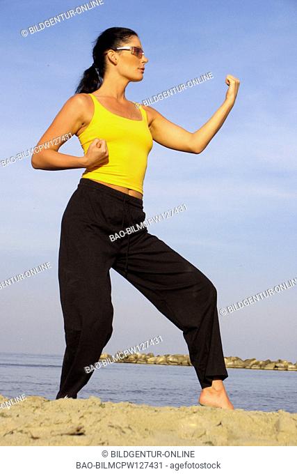 Woman with Chi gong practise on the beach