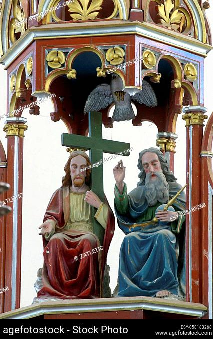 Holy Trinity, statue on the baptistery in Our Lady of Miracles Parish Church in Ostarije in Croatia