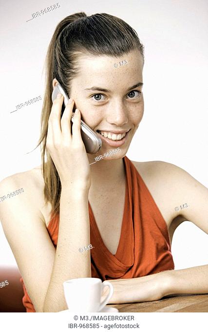 Teenage girl, woman, 17 years-old, holding cellphone, wearing a red dress