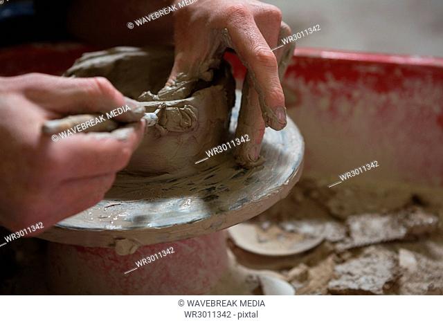 Male potters hand making a pot