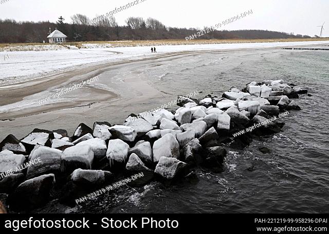 19 December 2022, Mecklenburg-Western Pomerania, Wustrow: The stone walls in front of the Baltic Sea beach of the Fischland peninsula are covered with ice