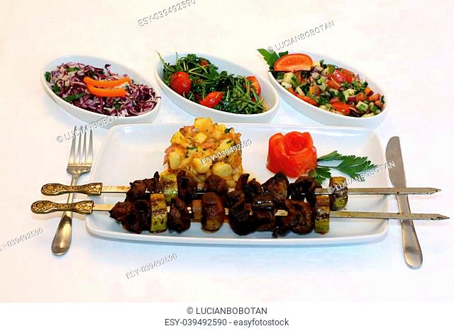 Grilled meat and vegetables with different types of salad