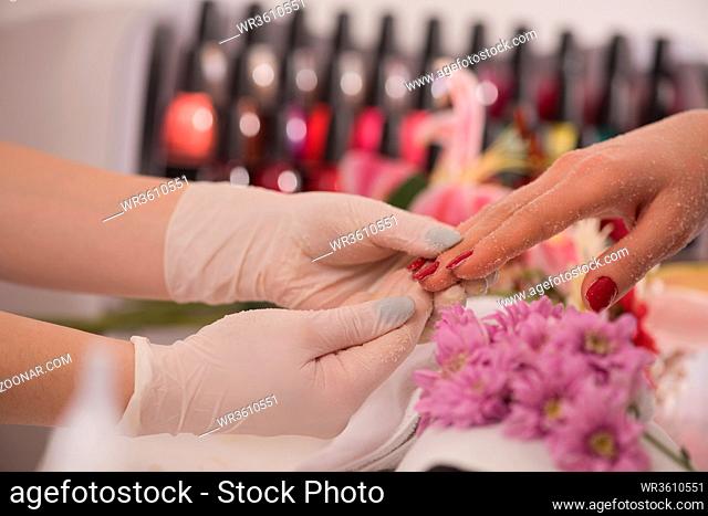 Woman hands receiving a manicure in beauty salon. Nail filing. Close up, selective focus