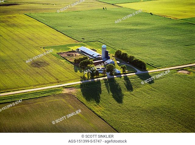 Agriculture - Aerial view of farmsteads and farmland in Spring / Central IA