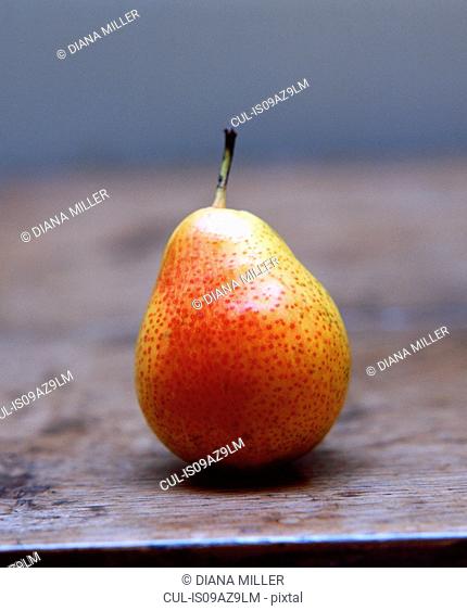 Comice pear on wooden table, close-up