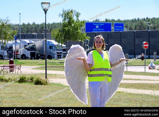 31 July 2020, Brandenburg, Michendorf: Emelie, dressed as guardian angel Jo, is standing on the grounds of the Michendorf-Nord rest stop