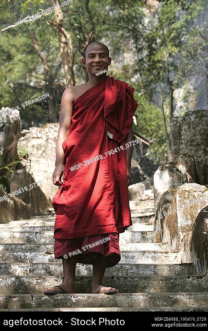 Portrait of a Buddhist monk standing on steps