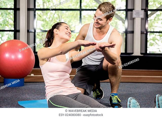 Trainer motivating a woman while doing crunches
