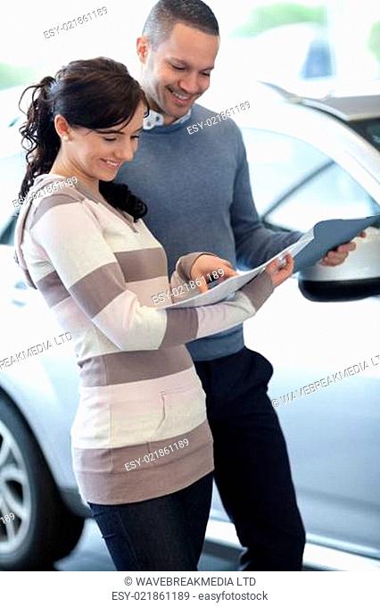 Couple holding documents in a carshop